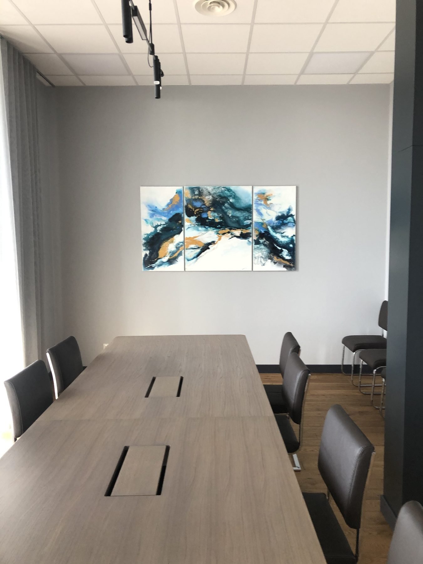Sala de reuniones: mesa, sillas y cuadro.